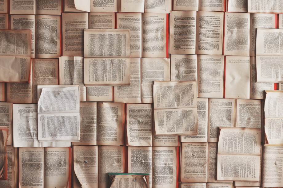 Dicht aneinandergereihte, geöffnete Bücher, die sich teilweise überlappen – eine visuelle Darstellung von Wissen und Literatur